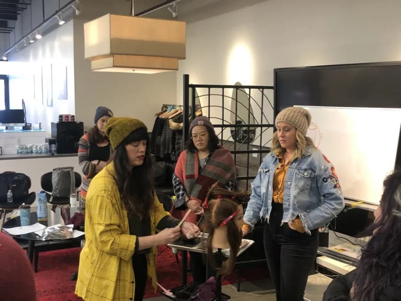 Tracy Vasquez demonstrating a cutting technique to a group of professional stylists.
