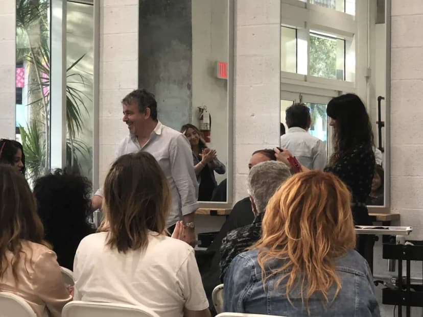 Hairstylists seated in rows watching a live cutting demonstration at the studio.